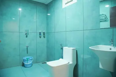 a bathroom with a toilet and a sink and a shower at Blue Vista Residency in Kalpetta
