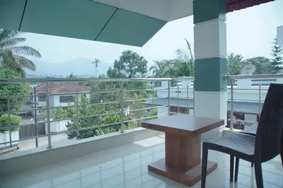 a balcony with a table and chairs and a view at Blue Vista Residency in Kalpetta