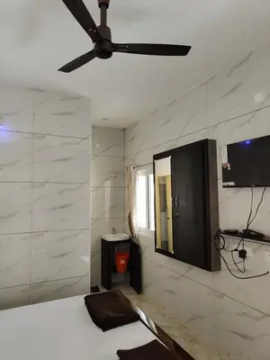 a bedroom with a ceiling fan and a bed at Eshwaraa Cottage in Palani
