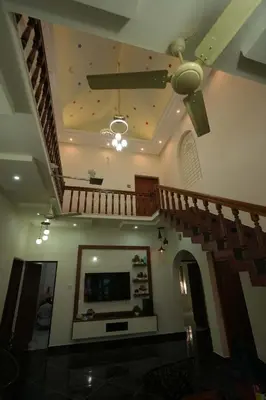 a living room with a staircase and a ceiling at Haritha Bio Park Homestay in Malayāttūr