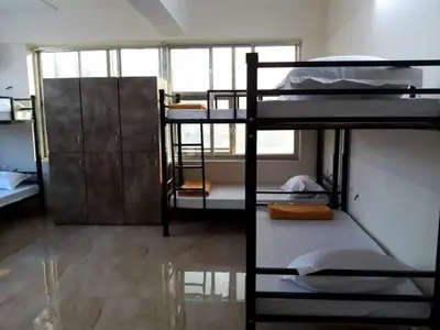a room with three bunk beds in a building at cozstel in Kozhikode