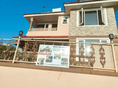 a balcony of a house with a sign on it at Honey Bee Cottages in Ooty