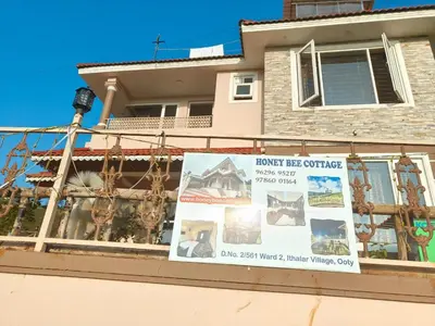 a sign in front of a house at Honey Bee Cottages in Ooty