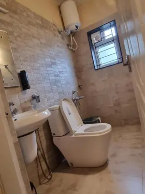 a bathroom with a toilet and a sink at Honey Bee Cottages in Ooty