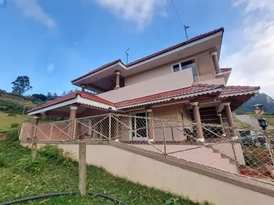 a house being constructed with a fence at Honey Bee Cottages in Ooty