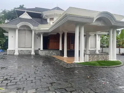a white house with columns and a driveway at Authentic Keralite holiday home for up to 6 in Kāladi