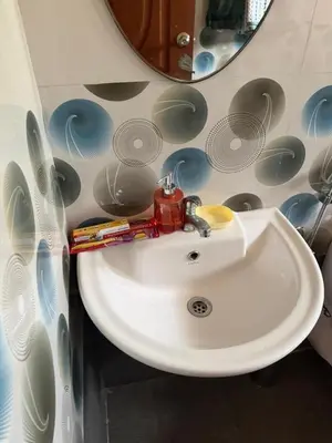 a white sink in a bathroom with a mirror at Authentic Keralite holiday home for up to 6 in Kāladi