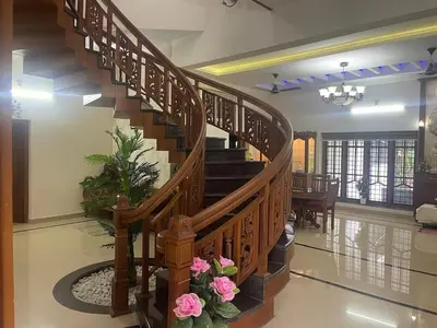 a spiral staircase in a home with pink flowers at Authentic Keralite holiday home for up to 6 in Kāladi