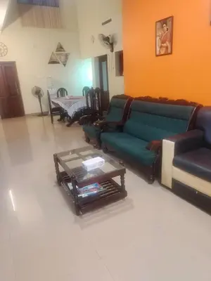 a living room with couches and a coffee table at Gayathri in Trichūr