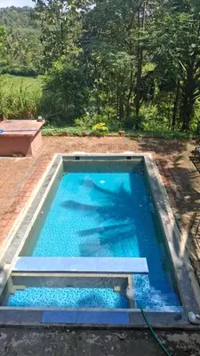 a large pool with blue water in a yard at Heritage tharavadu in Mananthavady