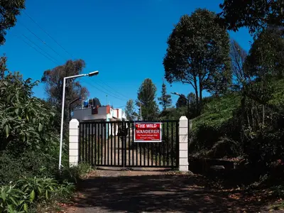 a gate with a sign on it with a sign on it at The Misty Woods in Kotagiri
