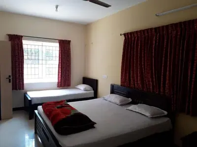 a bedroom with two beds and a window at The Misty Woods in Kotagiri