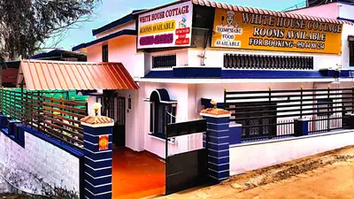 a building with a store with a sign on it at White House Cottage in Ooty