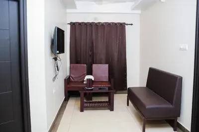 a living room with a couch and a chair at krishna suites guruvayur in Guruvāyūr