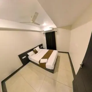 a bedroom with a bed in a white room at krishna suites guruvayur in Guruvāyūr