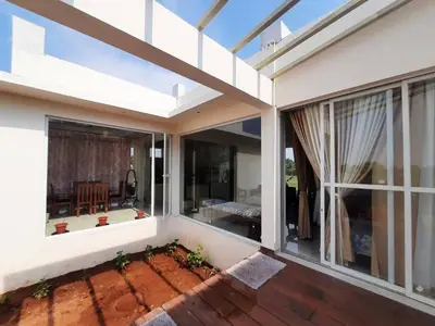 an open balcony of a house with a large window at Glass house in Pollāchi