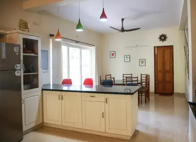 a kitchen with a large island with a black counter top at Family beach home-Cherai in Pallipuram