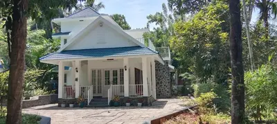 a small white house with a blue roof at Bougainvilla Luxury Individual Villa Kozhikode in Kunnamangalam