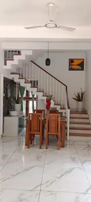 a dining room with a table and chairs and stairs at Bougainvilla Luxury Individual Villa Kozhikode in Kunnamangalam