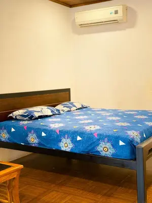 a bed in a room with a blue comforter at SRK luxe resort