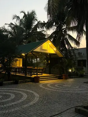 a building with a pavilion with a table and palm trees at SRK luxe resort