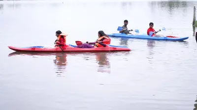 a group of people riding on kayaks on the water at Atharvam Resort in Cherai Beach