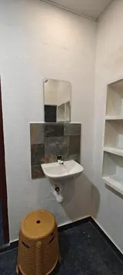 a bathroom with a sink and a mirror and a stool at Hayden in Kakkadampoyil