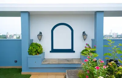 a blue house with a window and plants at 2BHK with Pool and Rooftop at the Centre of Kozhikode in Kozhikode