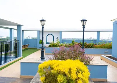 a balcony with two lights and flowers on a building at 2BHK with Pool and Rooftop at the Centre of Kozhikode in Kozhikode