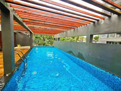 an indoor swimming pool with a large blue swimming poolvisor at 2BHK with Pool and Rooftop at the Centre of Kozhikode in Kozhikode