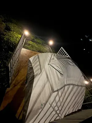 a white tent sitting on a staircase at night at Boche LuxCamp 1000 Acre in Wayanad