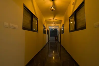 an empty hallway with yellow walls and a light fixture at Hotel Aeronest Residency in Calicut
