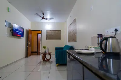 a kitchen with a counter and a living room at Hotel Aeronest Residency in Calicut