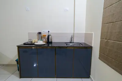 a small kitchen with a blue counter and a sink at Hotel Aeronest Residency in Calicut