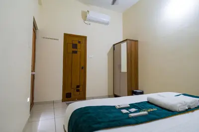 a bedroom with a bed with two towels on it at Hotel Aeronest Residency in Calicut