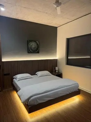 a bedroom with a large bed with a black wall at A private room in a luxury villa- The Water's Edge in Kotagiri