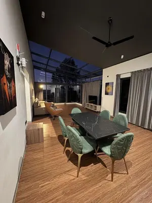 a living room with a black table and chairs at A private room in a luxury villa- The Water's Edge in Kotagiri