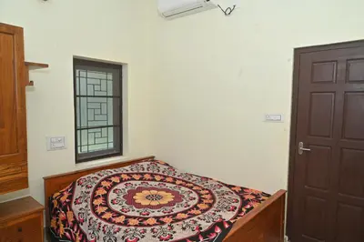 a bedroom with a bed and a window at Nisarga Greens in Chittūr