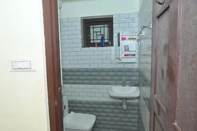 a bathroom with a sink and a toilet and a window at Nisarga Greens in Chittūr