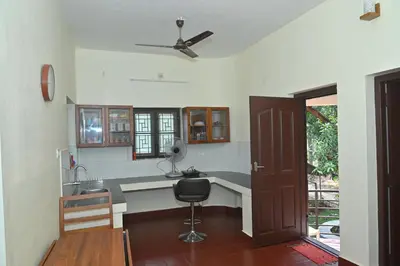 a kitchen with a desk and a ceiling fan at Nisarga Greens in Chittūr