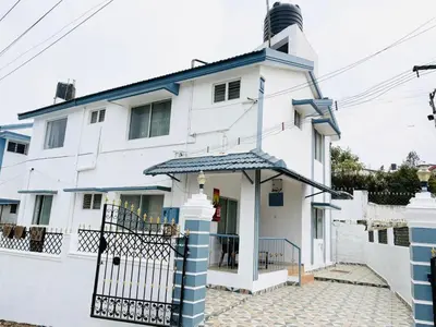 a white house with a lighthouse at Majestry Cottage in Ooty