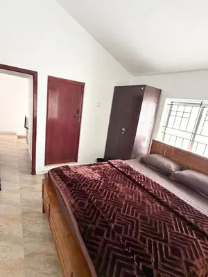 a bedroom with a large bed and a large window at Majestry Cottage in Ooty
