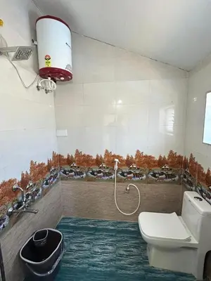 a bathroom with a toilet and a sink at Majestry Cottage in Ooty