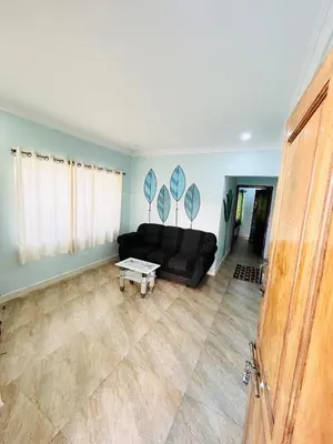 a living room with a black couch and a table at Majestry Cottage in Ooty