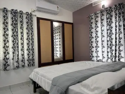 a bedroom with a bed and a window with curtains at Ravi's homestay in Cochin