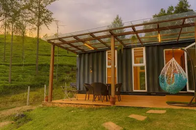a house with a pergola on a deck at The Leafy Nook Container Stay- 360 degree Tea Plantation near Ooty in Coonoor