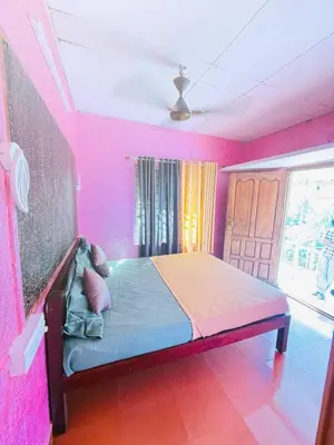 a bedroom with a bed in a pink room at Greenwoods Mist Villa in Munnar