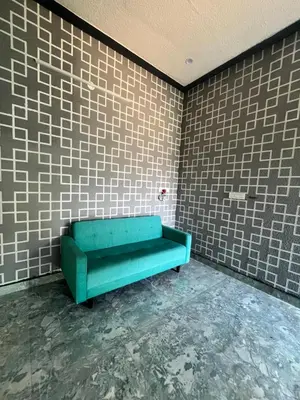 a green couch in a room with brick walls at Chamundi Temple-Hill View in Mysore