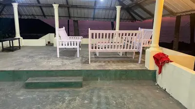 two white chairs sitting on a gazebo at Vibgyor home stay in Pallipuram