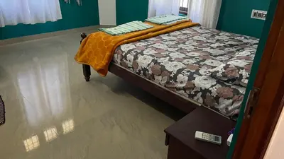 a bed with a quilt on it in a room at Vibgyor home stay in Pallipuram